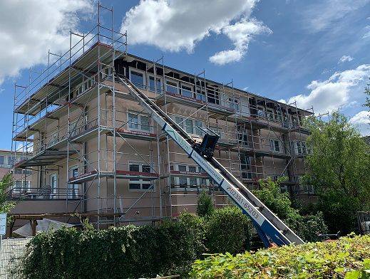 Gebäude mit Gerüst und firmiertem Kran